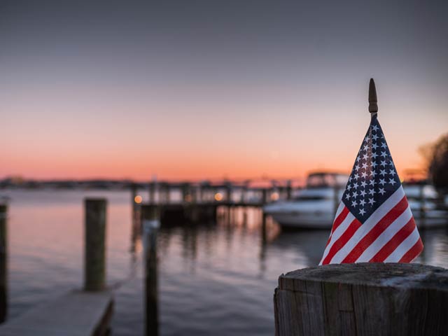 American Flag in Focus, Dock and Bay in Background