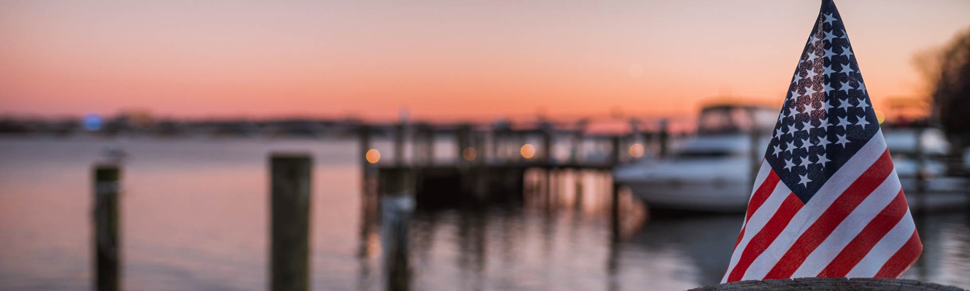 American Flag in Focus, Dock and Bay in Background